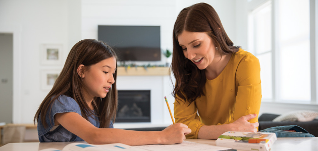 girl with mom working on homework with Mighty Minds product on table girl with mother sitting at counter with package of mighty minds