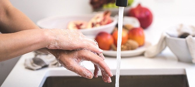 Healthy-Community-Banner person washing their hands at a kitchen sink
