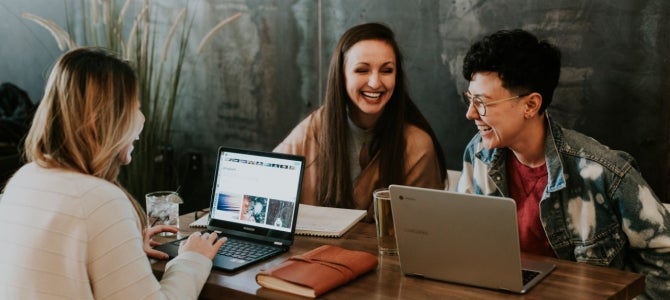 New Year's Goals1 friends sitting at a coffee shop on laptops laughing