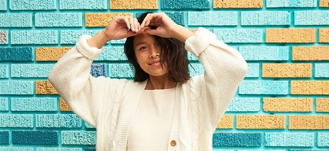 smiling girl in front of brick wall