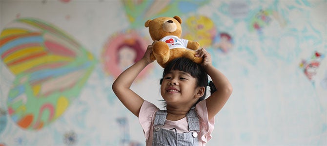 A Heart Full of Gratitude
Yu-Jie smiles as she plays with a teddy bear.